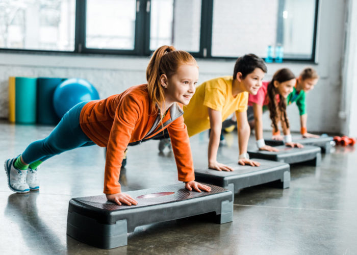 Children doing plank exercise with step platforms Children doing plank exercise with step platforms