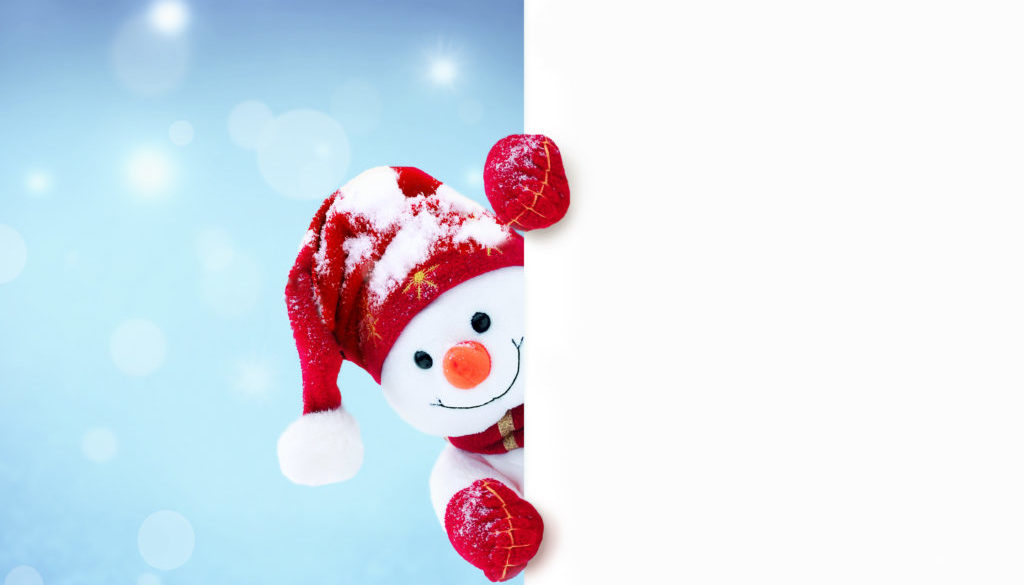 Little snowman in caps and scarfs on snow in the winter. Background with a funny snowman. Christmas card.
