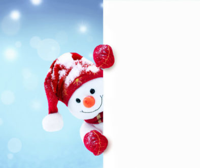 Little snowman in caps and scarfs on snow in the winter. Background with a funny snowman. Christmas card.