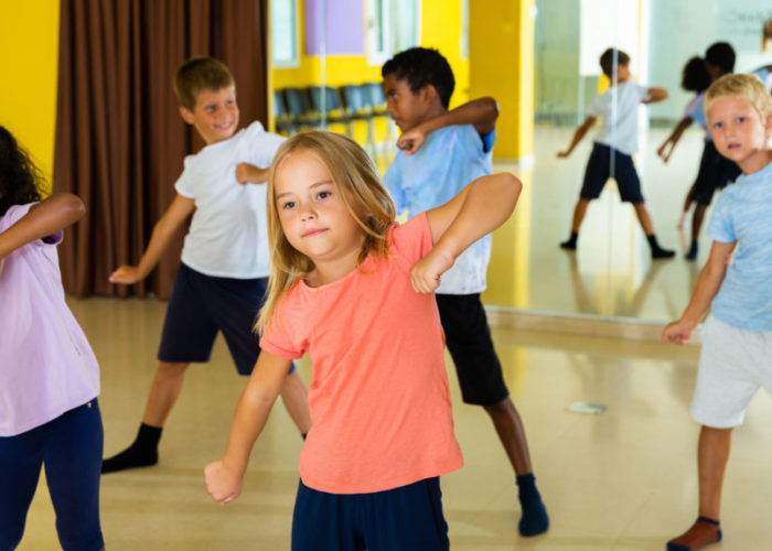 Portrait of smiling children practicing sport dance in modern da